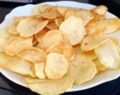 Step <p>Corte las patatas con una mandolina en rodajas finas. Fríalas de a poco en abundante aceite para que queden bien doradas y crujientes. Sale al gusto</p><p><br></p><p><br></p> illustration