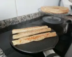 Step <p><span style="font-weight: normal;">En mi casa las que sobran (raro) si están frías, las envolvemos y las pasamos por la sartén espolvoreadas con azúcar (sin cortarse) llenando toda la sartén (5 o 6 filloas enrolladas) y dejamos que se caramelice el azúcar, se les da la vuelta con un plato y se vuelven a espolvorear con azúcar, y otra vuelta más.</span></p><p><br></p> illustration